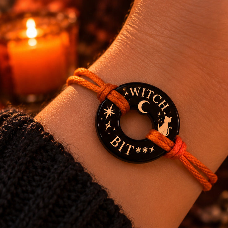 Black onyx Life Token bracelet with orange cord, WITCH at top and BIT** below, moon, stars, witch cat